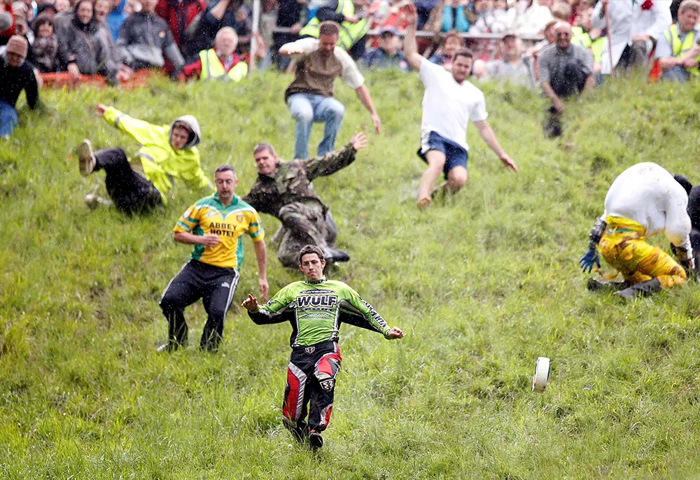 Cheese Rolling at Coopers Hill, Gloucester. Men run chase the cheese down the fill.